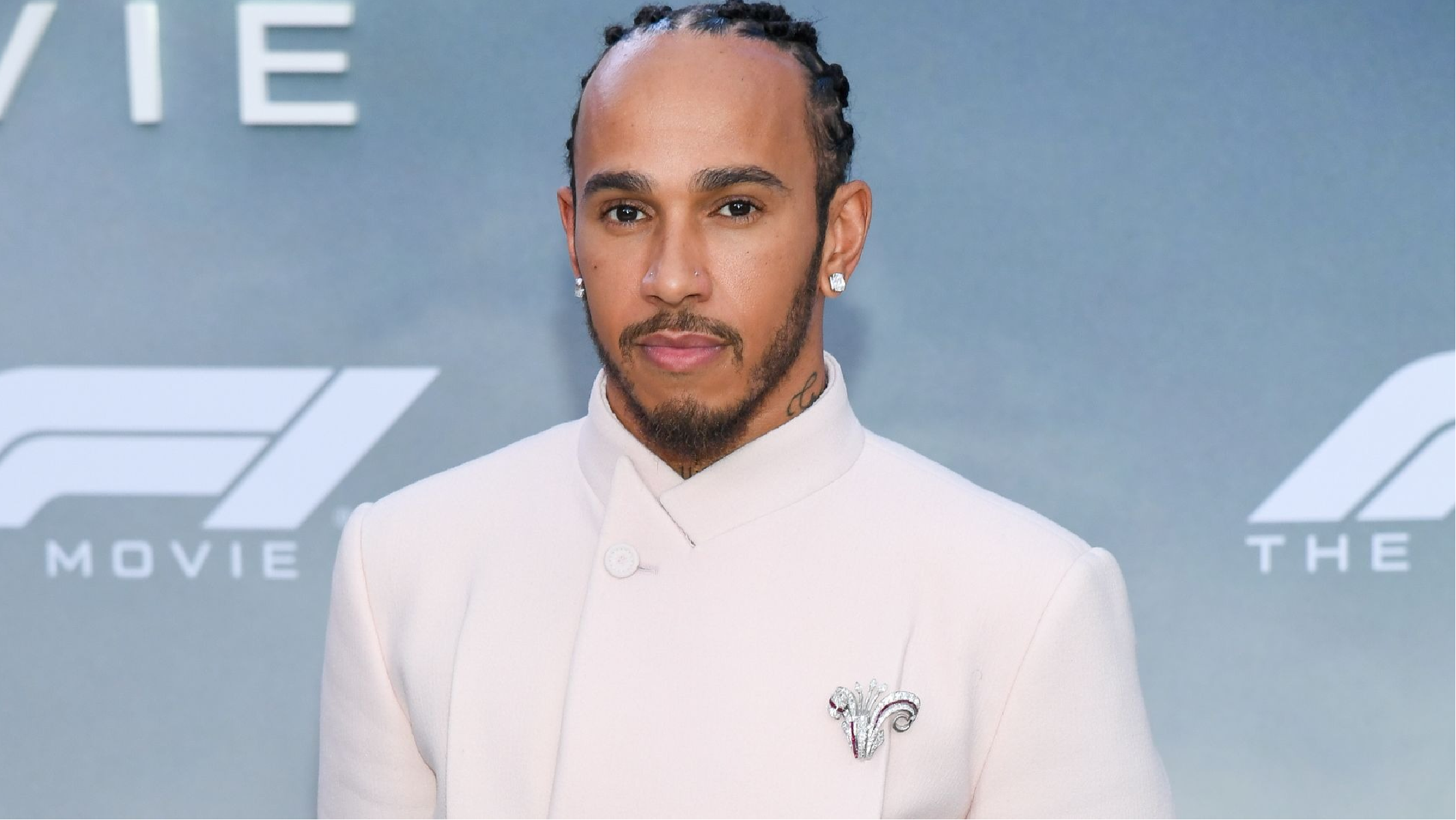 Lewis Hamilton wearing the bright yellow zip-up hoodie with black drawstrings at the 2025 U.S. F1 Grand Prix in Austin, featuring LH44 logo on the chest and vertical ‘HAMILTON’ print on the back, showcasing motorsport-inspired streetwear style.