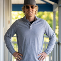 Stick star Owen Wilson wears a stylish gray polo t-shirt, adding a sleek casual touch to the scene.