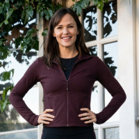 The Last Thing He Told Me star Jennifer Garner wears a stylish brown jacket, adding a sleek and modern touch to a casual home setting.