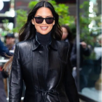 Olivia Munn wears a sleek black leather trench coat in Midtown NYC, showcasing a modern Matrix-inspired style.