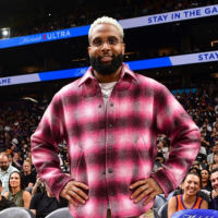 Odell Beckham Jr. courtside in a stylish fuchsia, burgundy, and white plaid shacket at the Denver Nuggets vs Phoenix Suns game.