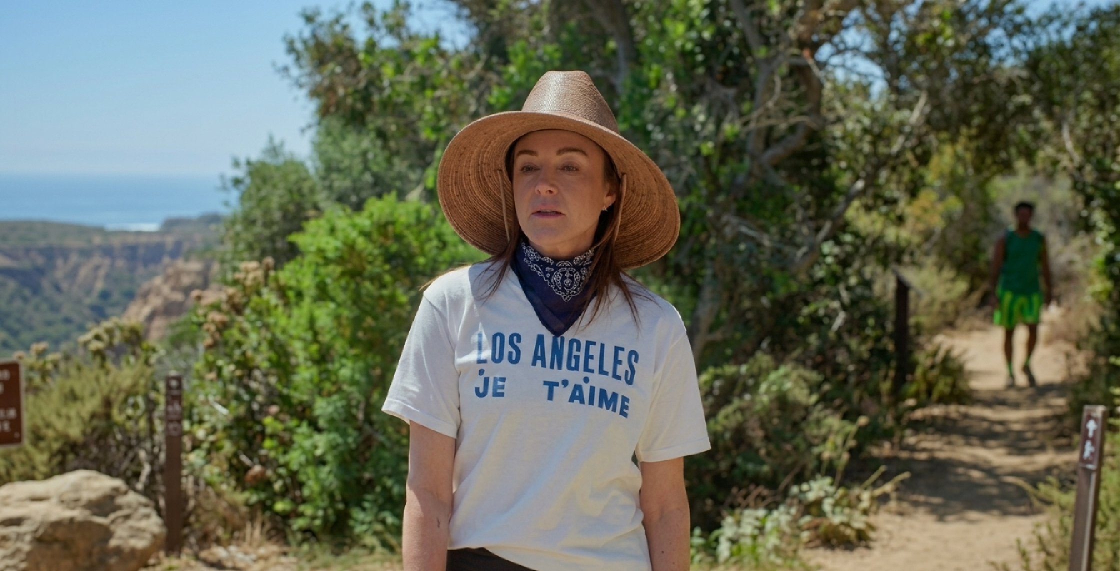 Slim-fit white graphic tee with bold blue “Los Angeles Je T’aime” text inspired by Christa Miller in Shrinking