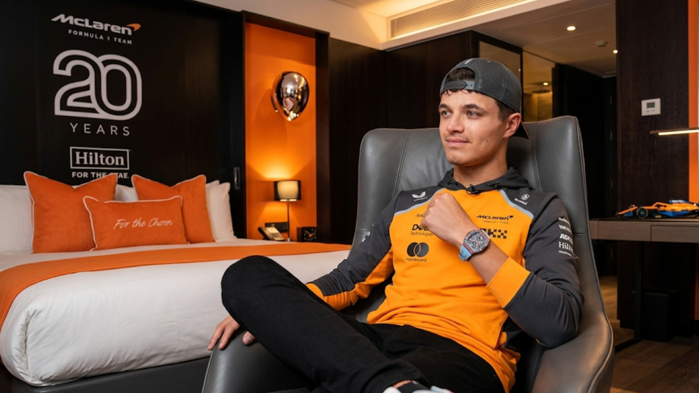 McLaren 2025 Team hooded sweatshirt in papaya orange and black with official F1 sponsor logos and racing-inspired design