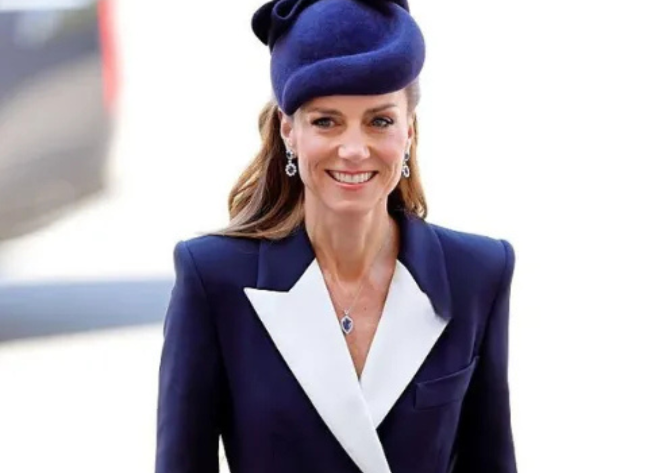 Catherine Princess of Wales wearing a navy blue structured long coat with white lapels and poppy pin during ANZAC Day commemorations at Westminster Abbey