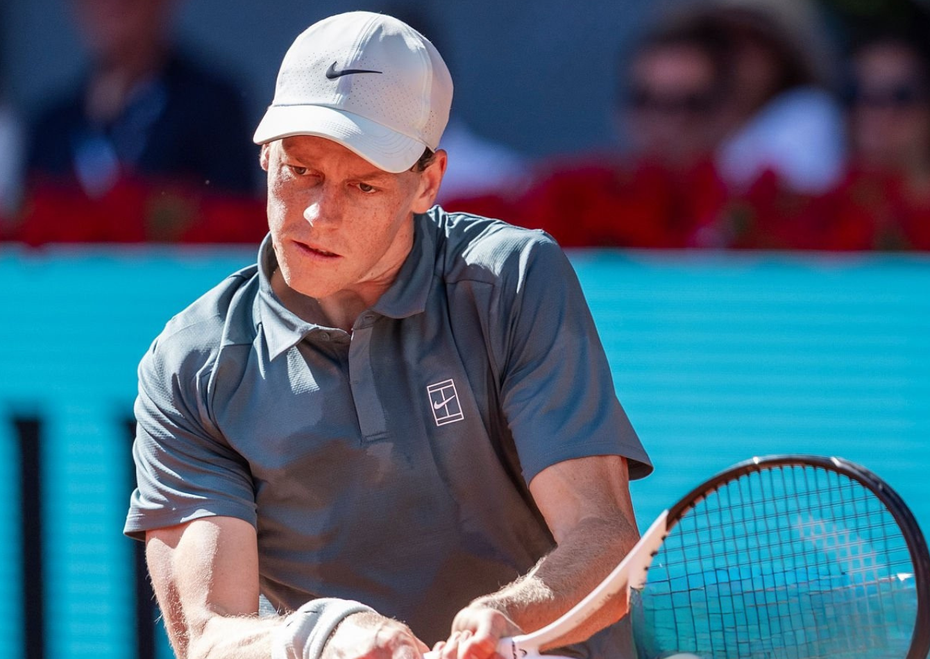 Jannik Sinner wearing slate grey polo shirt, dark charcoal shorts, and light grey cap during Men’s Singles Round of 32 at Mutua Madrid Open 2026 in Madrid on April 26, 2026