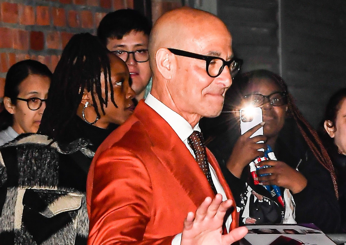 Stanley Tucci wearing a vibrant red double-breasted blazer with peak lapels at The Devil Wears Prada 2 NYC Cinema Society screening in 2026