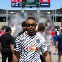 Jalen Hurts Fanatics Flag Football Classic 2026 white jersey with navy chevron accents, Raising Cane’s logo on chest, and athletic short-sleeve design inspired by Jalen Hurts game-day style