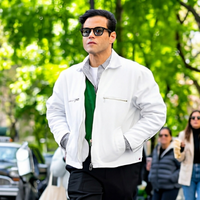 Rami Malek Upper East Side white zip-up jacket styled with black trousers and layered green shirt in NYC streetwear fashion look 2026