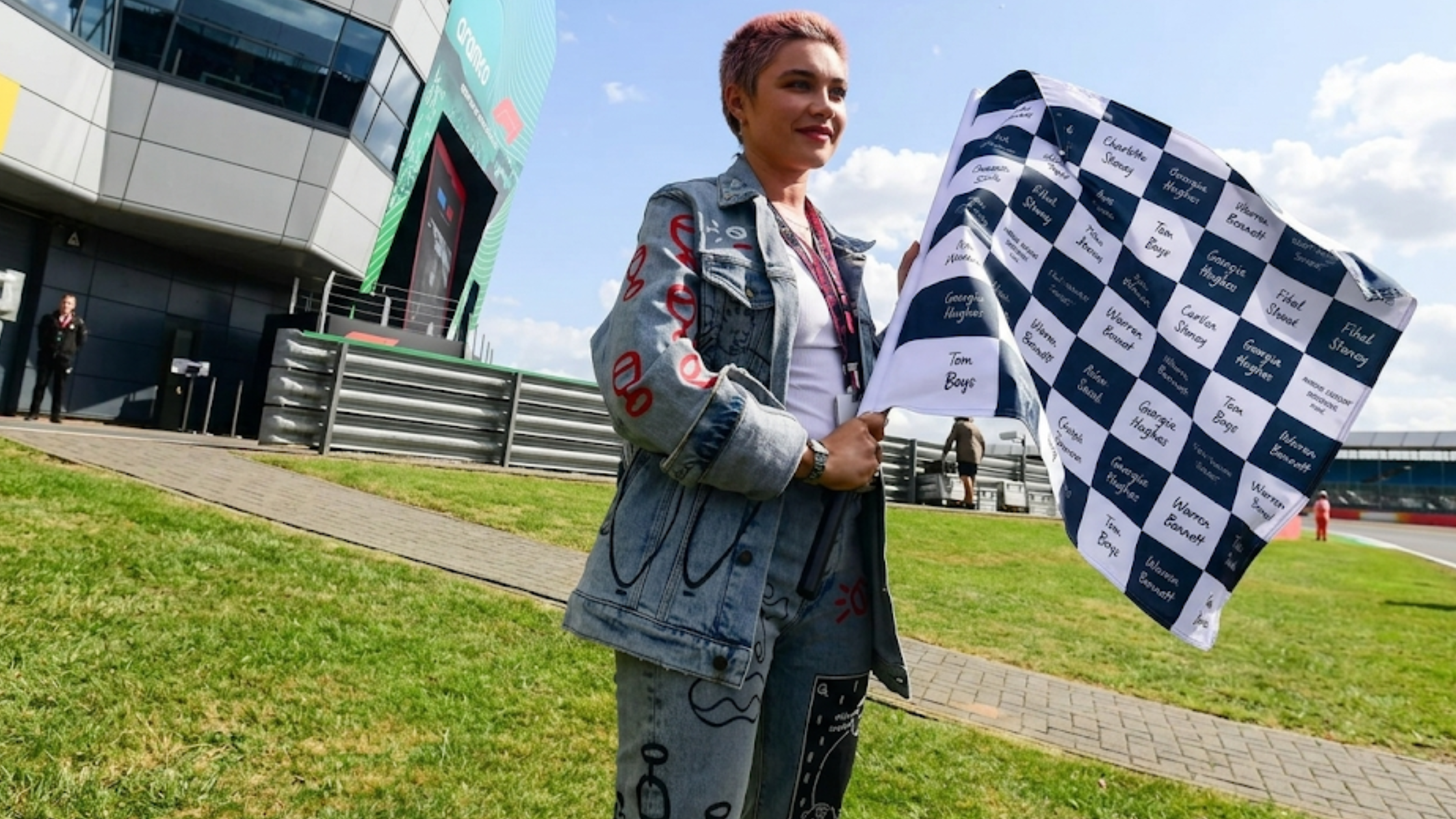 Florence Pugh July 2025 F1 Grand Prix Silverstone distressed light-wash denim jacket with red hand-painted details