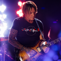 Keith Urban New Year’s Eve Live black graphic T-shirt with circular concert-inspired design, red accent details, abstract soundwave-style artwork, crewneck casual streetwear fit.