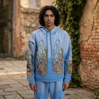 Who Decides War blue pullover hoodie featuring stained-glass graphics, fiery flame artwork, and oversized streetwear silhouette