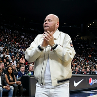 Fat Joe New York Knicks vs Atlanta Hawks cream leather varsity jacket with navy striped ribbing, silver zipper, embroidered patches, and luxury courtside streetwear style.