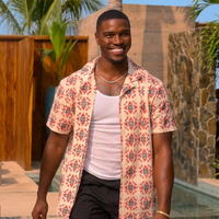 Damari Davis wearing a cream resort short sleeve shirt with coral pink geometric tile print and camp collar design from Perfect Match S04