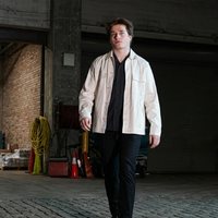 Macklin Celebrini-inspired white utility chore jacket with oversized chest pockets and minimalist design reflecting Oilers vs Sharks game-day streetwear style