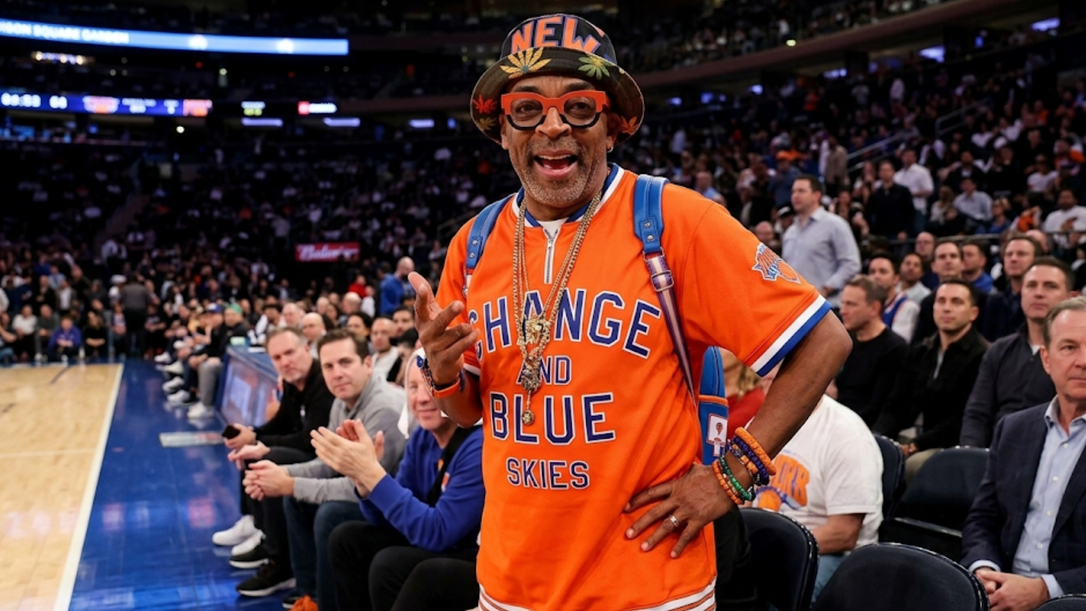 Spike Lee Cleveland Cavaliers vs New York Knicks orange graphic T-shirt with “Orange and Blue Skies” typography, striped ribbed collar, and athletic fit