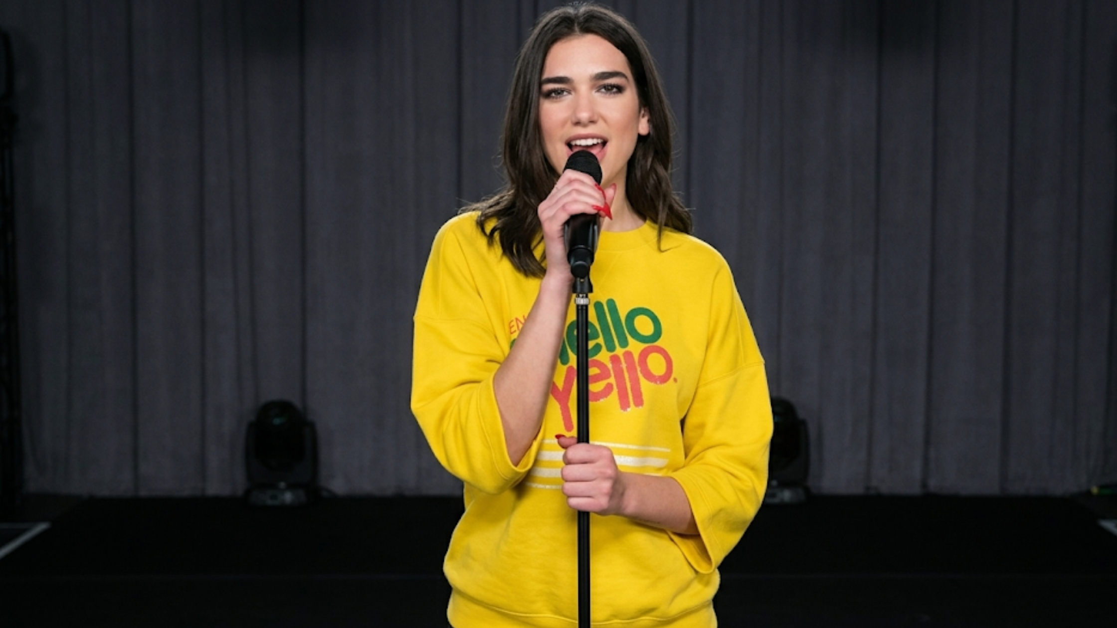 Dua Lipa Mello Yello oversized yellow sweatshirt retro soda graphic varsity stripe drop shoulder streetwear outfit