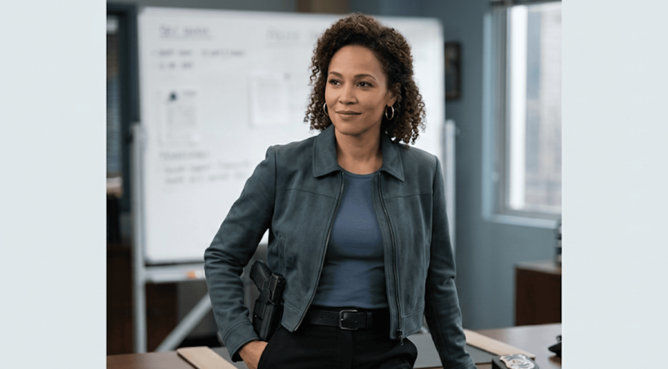 Logan Browning wearing a blue cropped utility jacket with chest patch pockets and a sharp spread collar